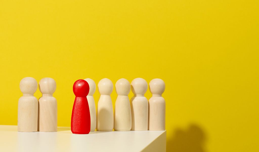 wooden people with one red